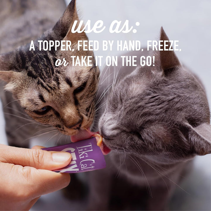 Two cats eating from a purple treat bag held by a person with text about using the product. Tiki Cat Stix Mousse Treats, Variety Pack with Salmon, Chicken, and Duck